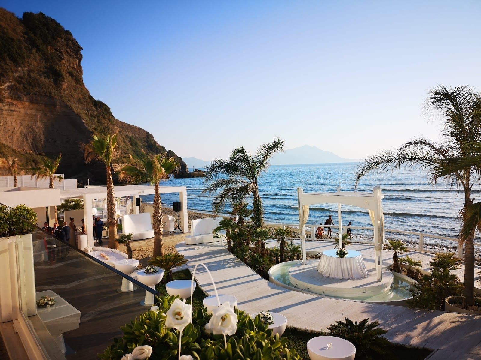 Wedding ceremony setup on a beach with a canopy and a table.