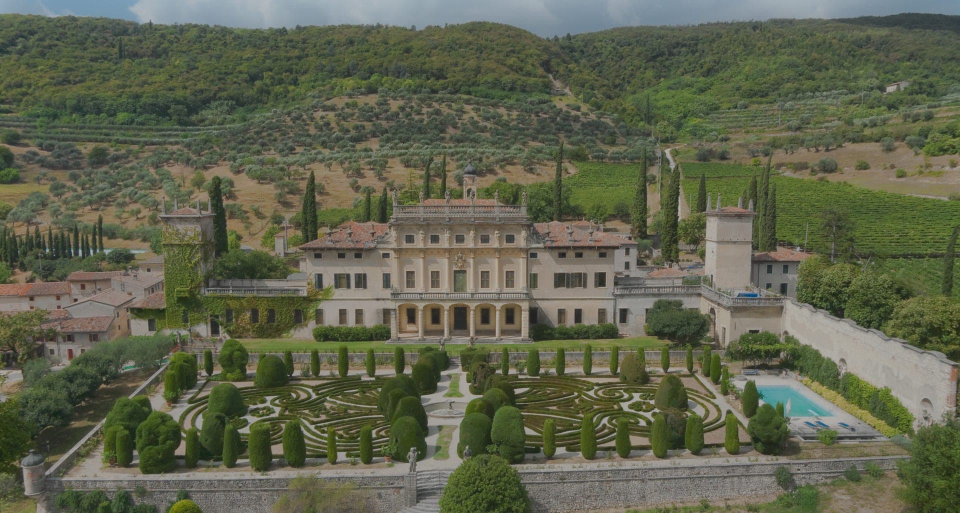 Aerial view of Villa Arvedi with formal gardens and a swimming pool.