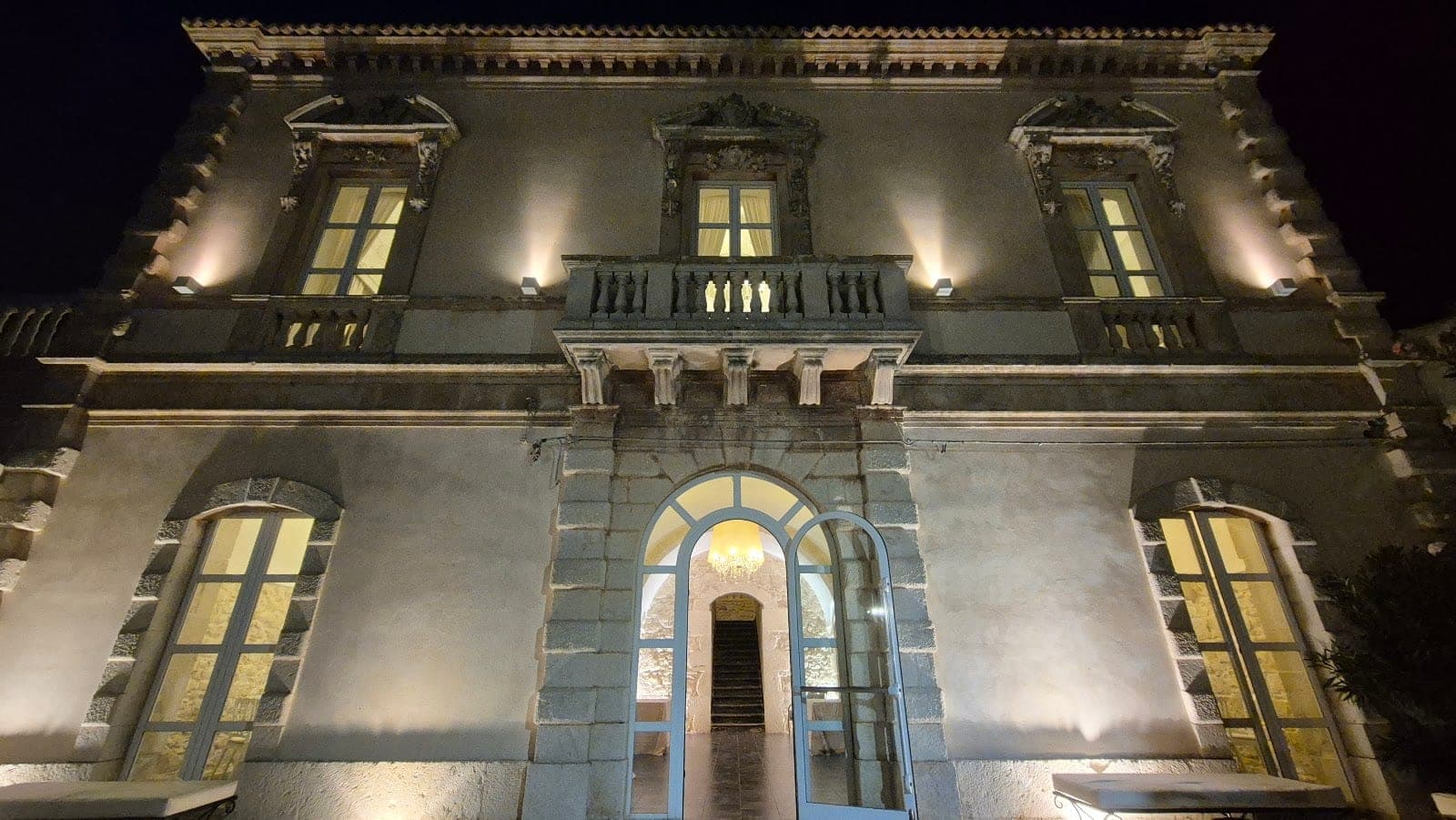 The illuminated exterior of Villa Gerosa Dimmi Si at night.