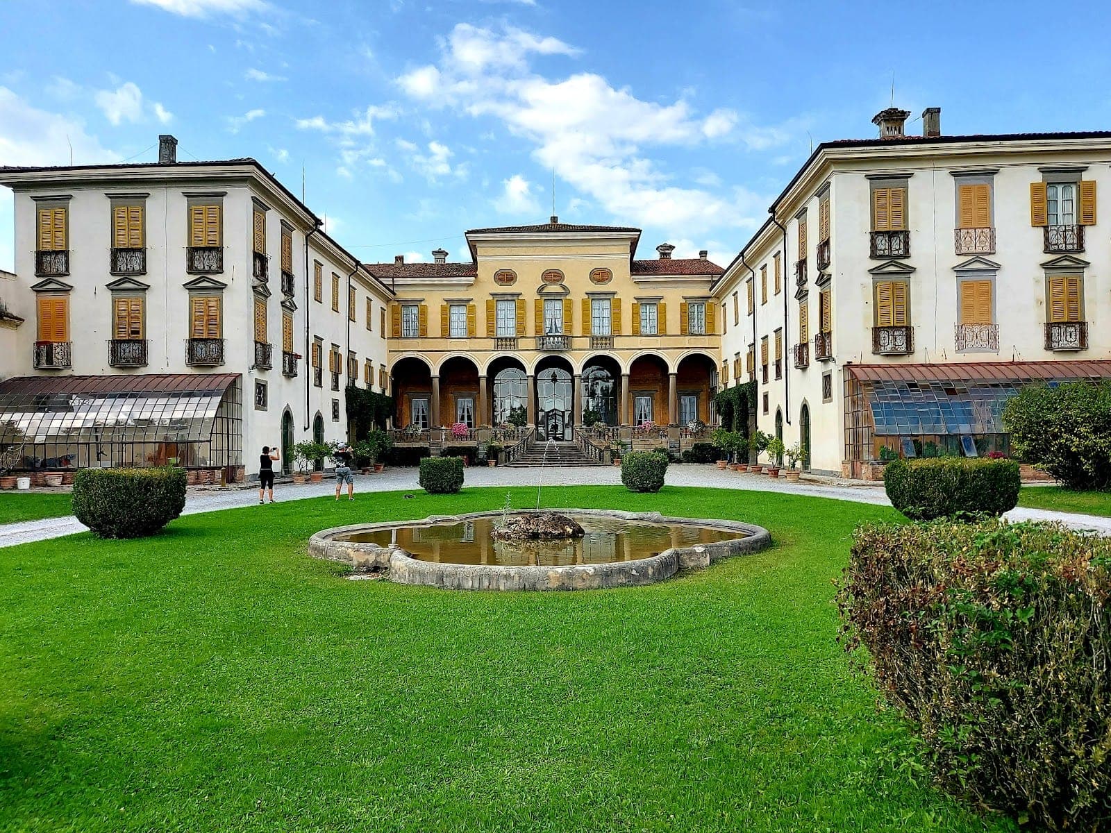 Villa Gromo exterior with a fountain and manicured lawn