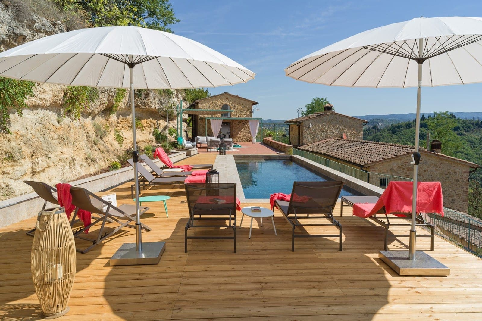Outdoor swimming pool with lounge chairs and umbrellas at Villa La Coccola.