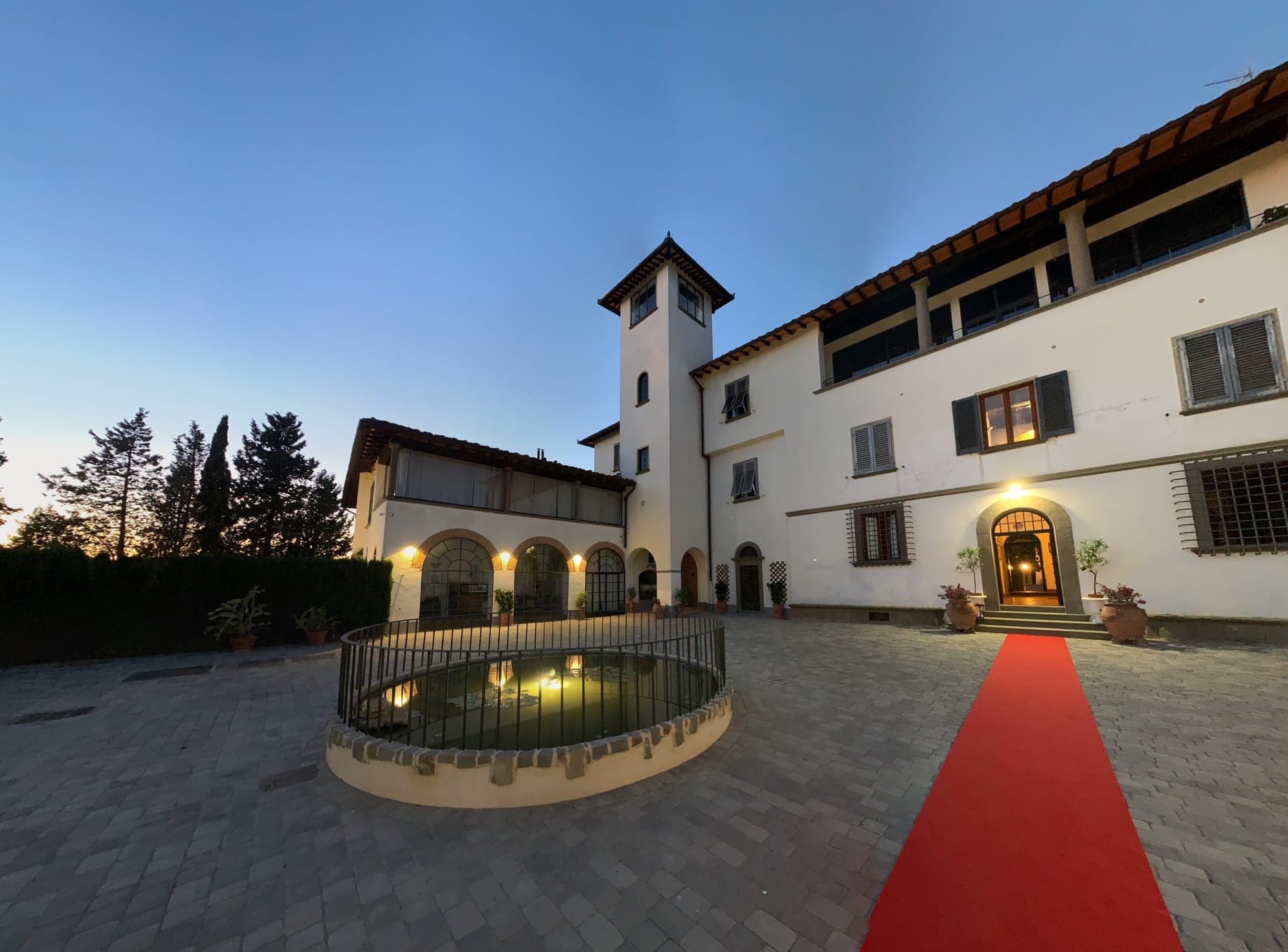 Exterior of Villa Le Sorti at dusk with a red carpet.