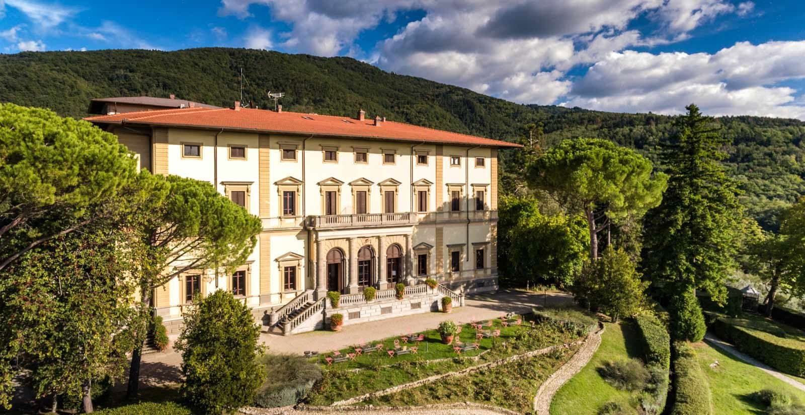 Villa Pitiana Hotel exterior with manicured gardens and rolling hills in the background.
