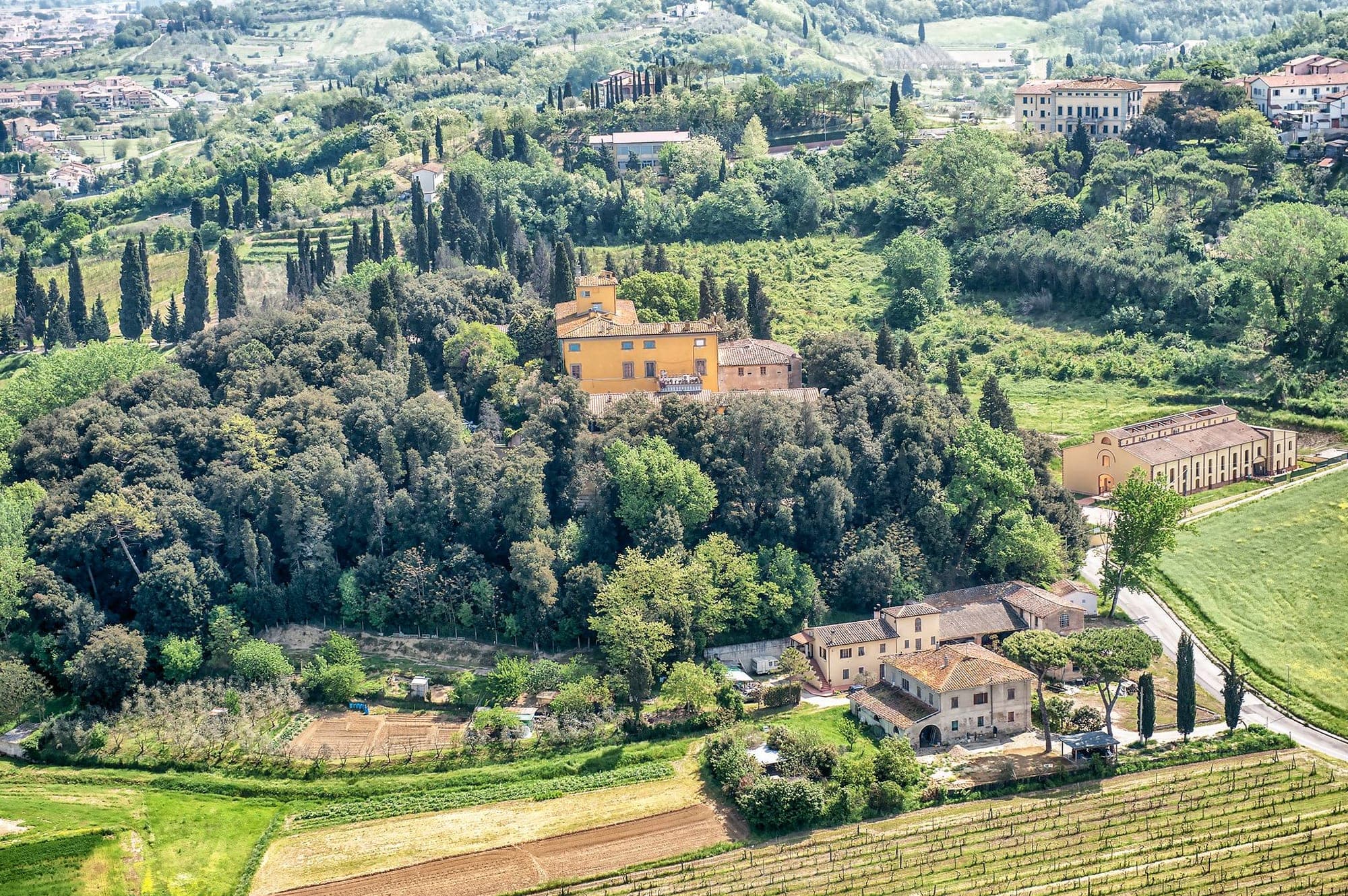 Aerial view of Villa Sonnino surrounded by trees and vineyards.