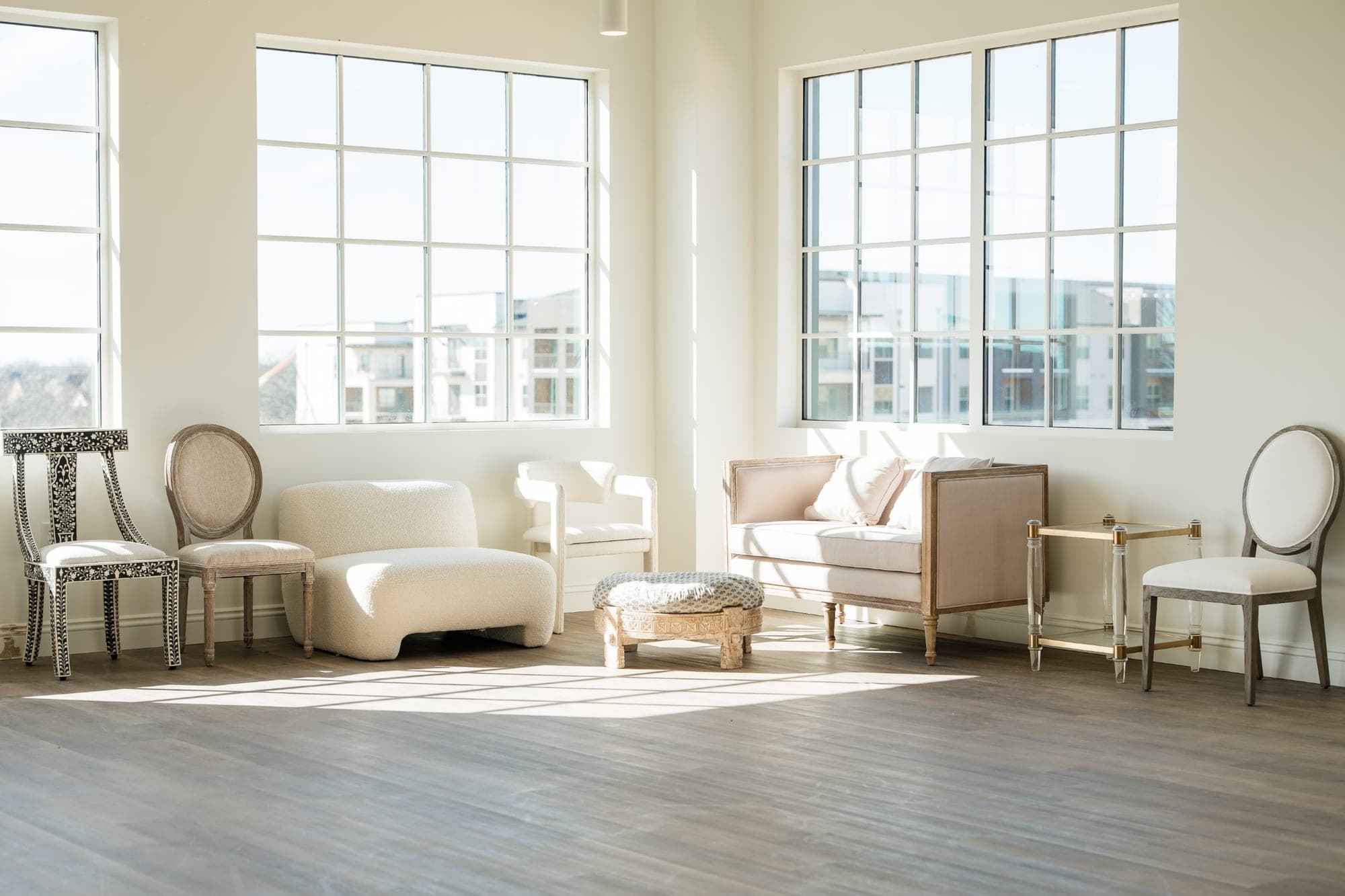 A bright room with large windows and various seating arrangements.