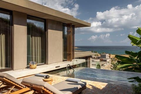 Timber and stone pavilions above the cove at Domes Zeen Chania in western Crete