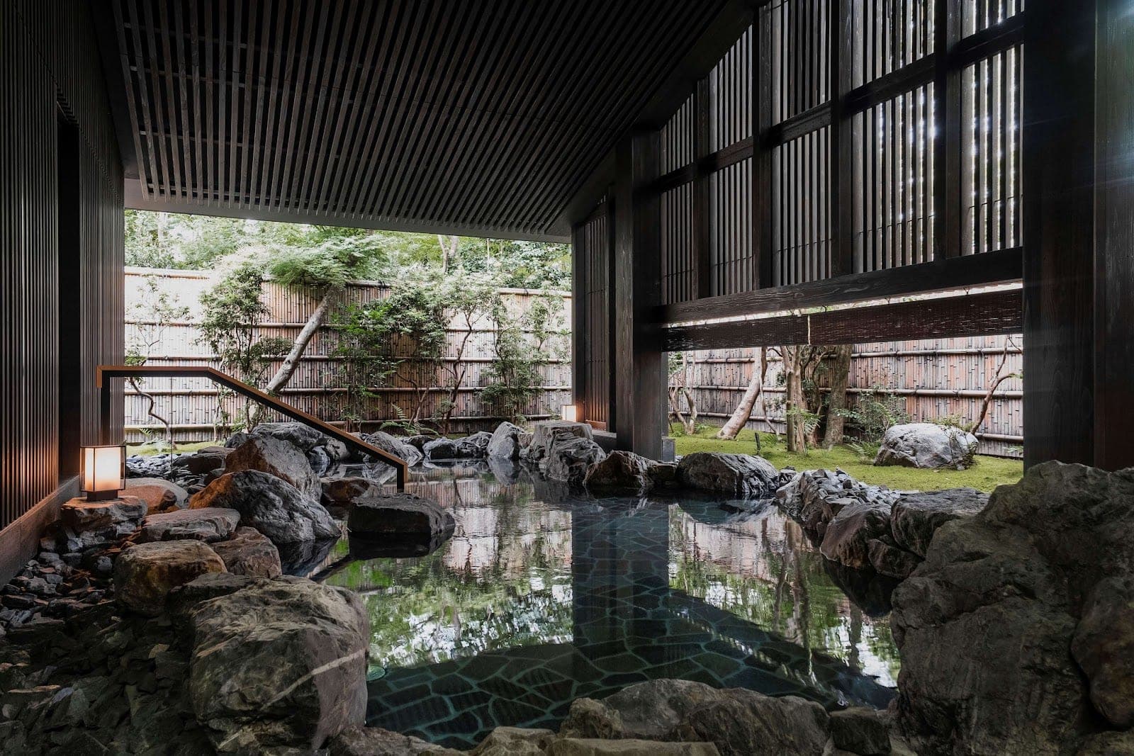 Moss, stone paths and low timber pavilions in the forest at Aman Kyoto