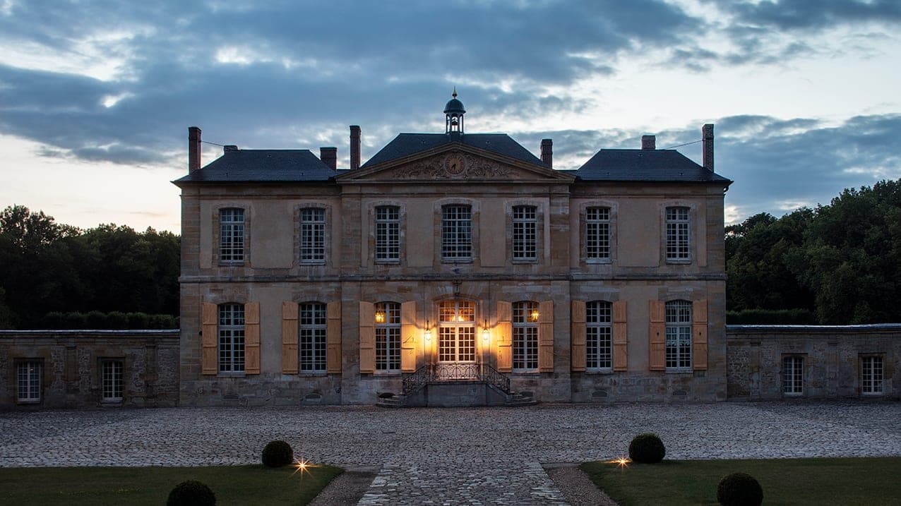 The 17th-century facade of Château de Villette above its Le Nôtre lawns and lake