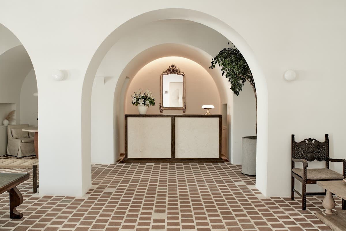 Whitewashed arches and a stone courtyard at Parīlio on Naoussa bay, Paros